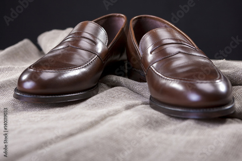 Shoes Concepts and Ideas. Closeup of Stylish Modern Brown Leather Penny Loafer Shoes Against Black Background.