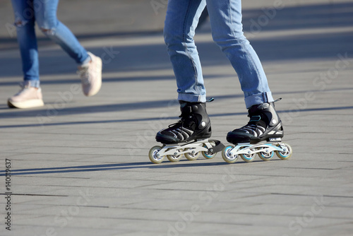legs rolling around on roller skates in the background walking person.