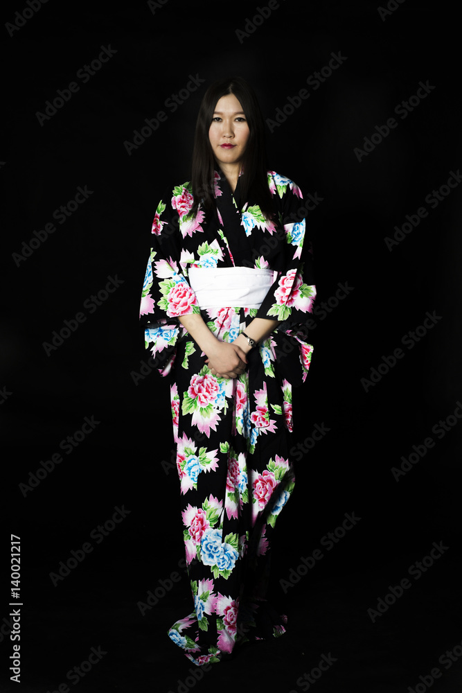 Japanese girl in traditional Japanese kimono on black background.