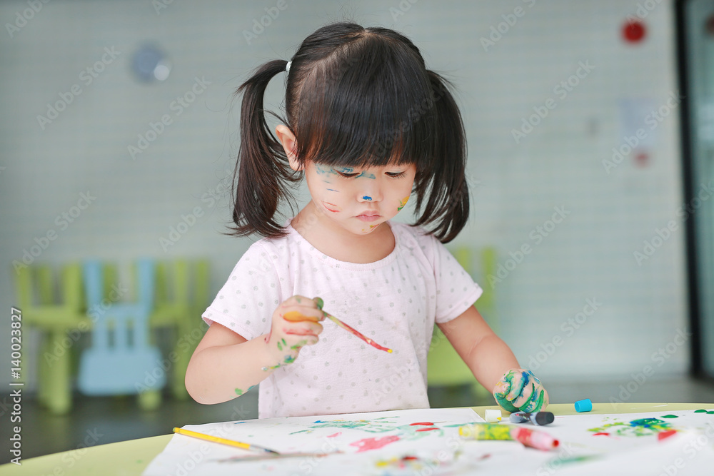 Asian child girl painting with paintbrush and water colors. Asian child girl painting with paintbrush and water colors.