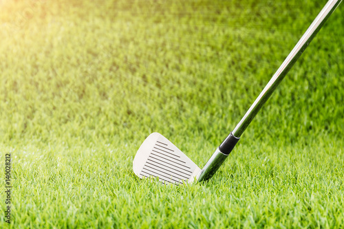 Golf club on green grass with sunlight
