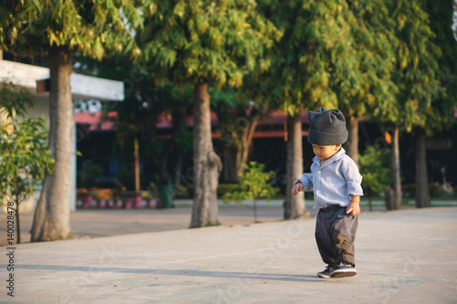 Asian boy learning to walk and fall