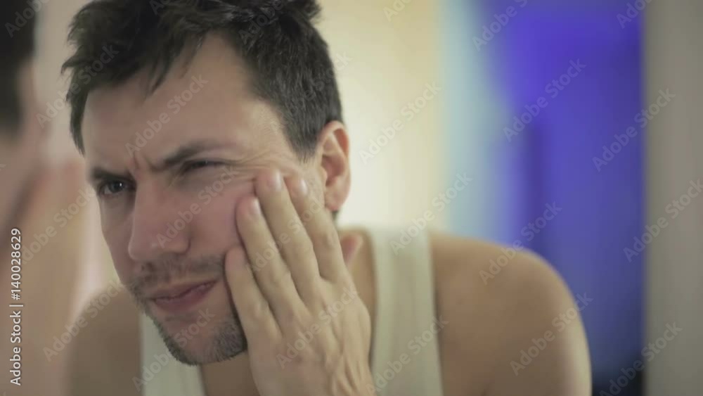 Close up. Unshaven man looking in the mirror. Close up. Unshaven man looking in the mirror.