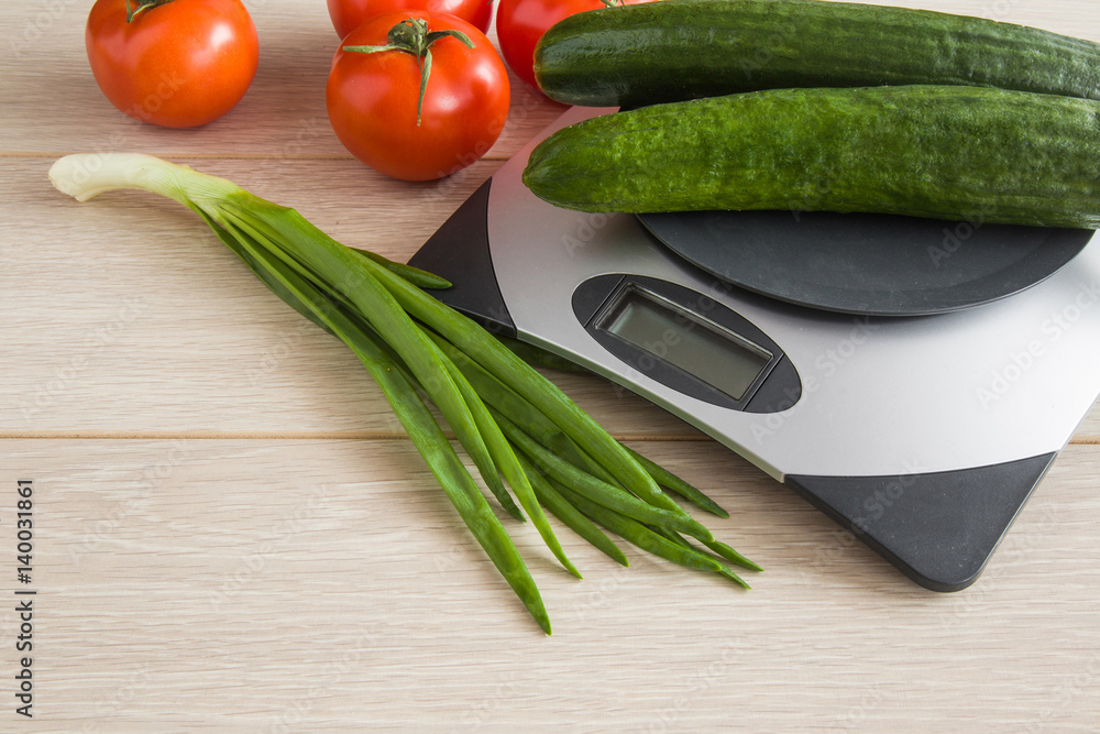 Cucumbers on the weighing scales on the table in the kitchen. Healthy eating and lifestyle.