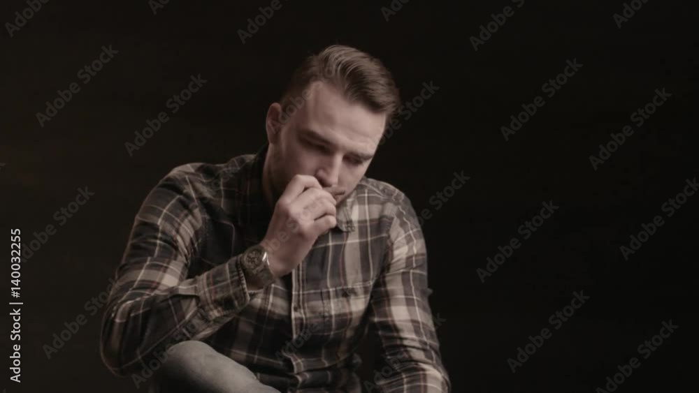 Handsome man with a beard smoking cigar in studio.A man with a beard cigar burns Handsome man with a beard smoking cigar in studio.A man with a beard cigar burns