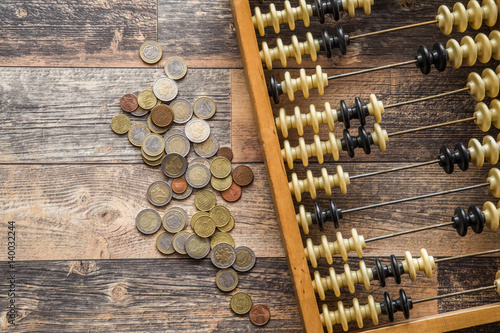 Money with old abacus on the wooden table. Euro coin stocks from different countries.