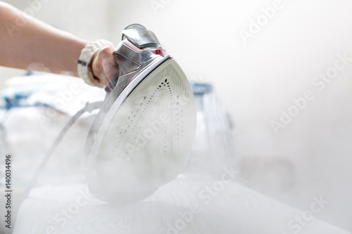 Woman uses irons, ironing at home.