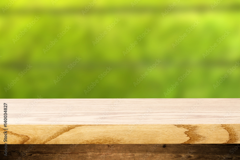 Top wooden table and in the background blurred plants as a theme spa. Empty space to paste and mounting of different products. Top wooden table and in the background blurred plants as a theme spa. Empty space to paste and mounting of different products.