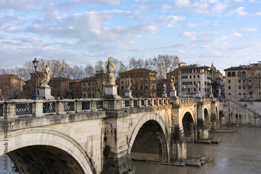 Sant Angelo bridge over the Tiber river, Rome, Italy, buildings, trees, blue sky at sunset