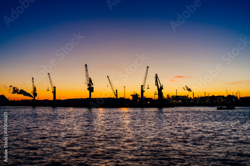 Hamburger Hafen mit Hafenkränen beim Sonnenuntergang