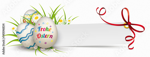 Frohe Ostern Ostereier im Gras mit Blumen und einem Papierzettel mit einem roten Band