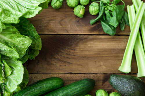 Products containing folic acid - B9 vitamin . Green vegetables on wooden background. Celery, avocado, Brussels sprouts, basil, cucumber, romaine salad
