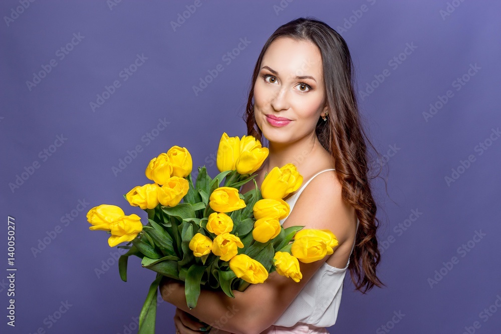 Young beautiful woman holding a bouquet of yellow tulips. Spring. Young beautiful woman holding a bouquet of yellow tulips. Spring.