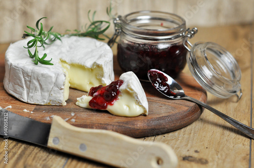 Delicious camembert cheese with cranberry on wooden background