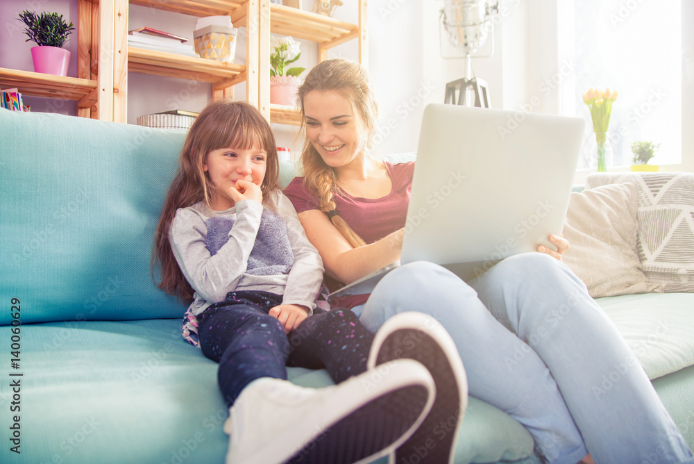 Mother and daughter using laptop together, happy loving family Mother and daughter using laptop together, happy loving family