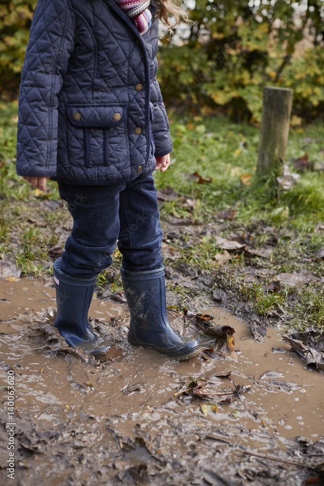 Close Up Of Girl Splashing In Puddle On Winter Walk Close Up Of Girl Splashing In Puddle On Winter Walk
