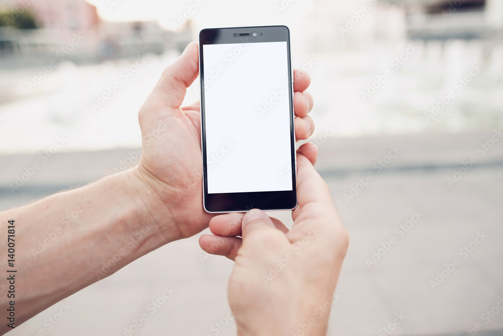 Videocall via mobile phone. Hands holding blank screen smartphone with clipping path for screen