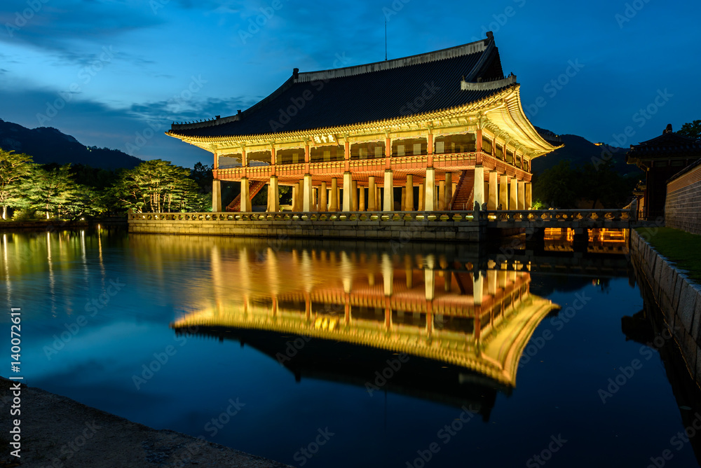 Obraz premium Pałac Gyeongbokgung nocą w Korei Południowej, z nazwą pałacu „Gyeongbokgung” na znaku