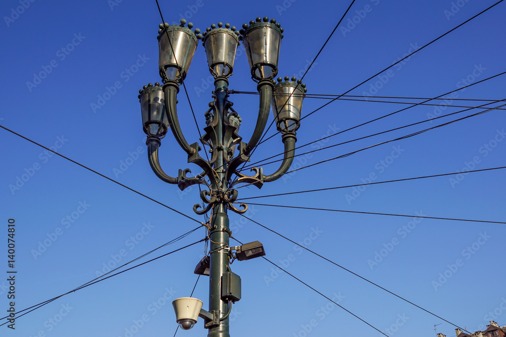 Head of an old fashioned victorian style lampost against a blue sky Head of an old fashioned victorian style lampost against a blue sky