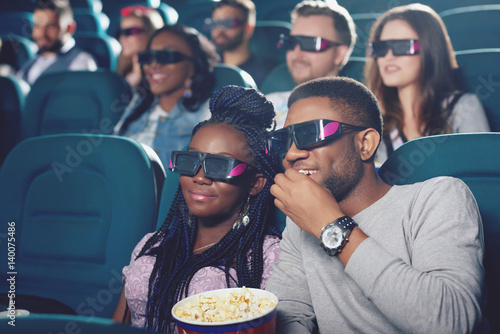 Couple of africans watching film in 3d glasses.