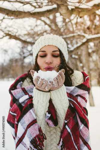 	Young happy cheerful woman enjoying winter in snowy park
