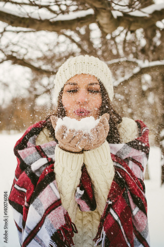 	Young happy cheerful woman enjoying winter in snowy park