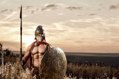 Fotografie Strong Spartan warrior in battle dress with a shield and a spear