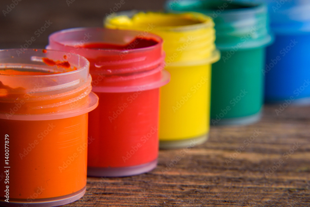 jars with colorful gouache paints on wooden background jars with colorful gouache paints on wooden background