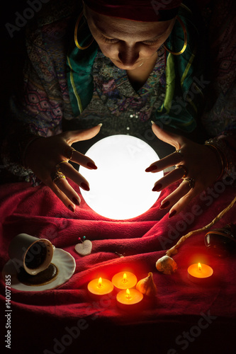Foto Female fortuneteller with her hands above crystal ball