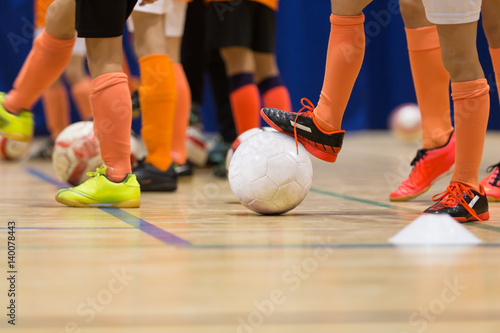 Football futsal training for children. Indoor soccer young player with a soccer ball in a sports hall. Sport background. photo