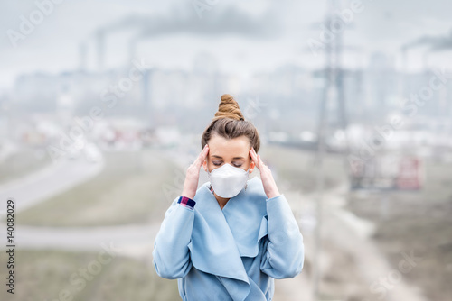 Plakat Młoda kobieta w masce ochronnej czuje się źle w mieście z zanieczyszczeniem powietrza z ruchu i produkcji. Koncepcja smogu
