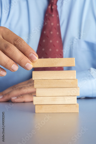 Hand arranging wood block stacking as step stair. Business concept for growth success process.