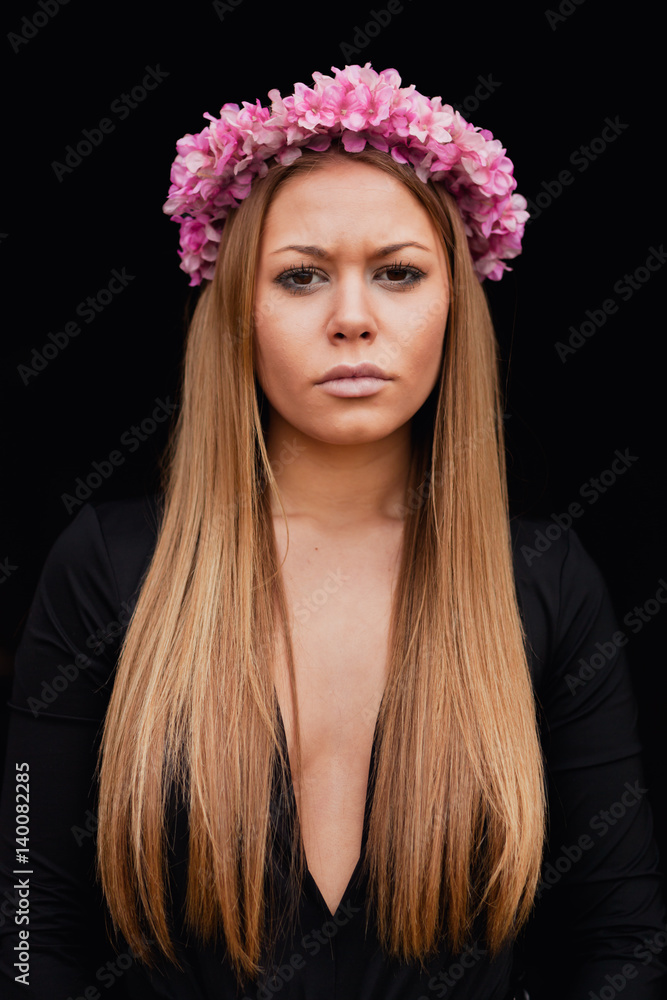 Beautiful portrait of a blonde girl with a pink crown of flowers