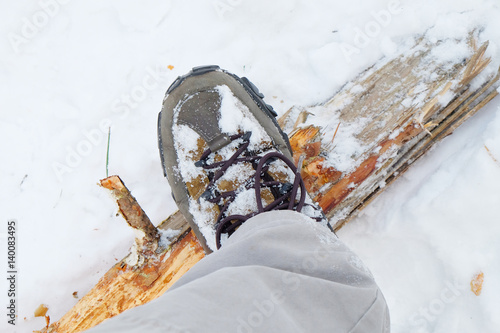 tourist boot on a tree trunk in winter forest