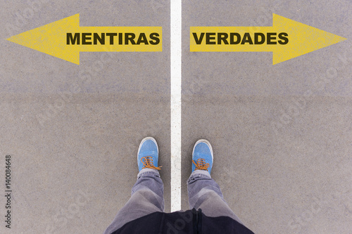 Obraz na płótnie Mentiras e verdades, Portuguese text for Lies and Truth on asphalt ground, feet and shoes on floor w salonie