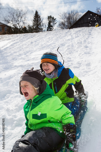 Slika na platnu Boys riding a sled, tobogganing down the snow