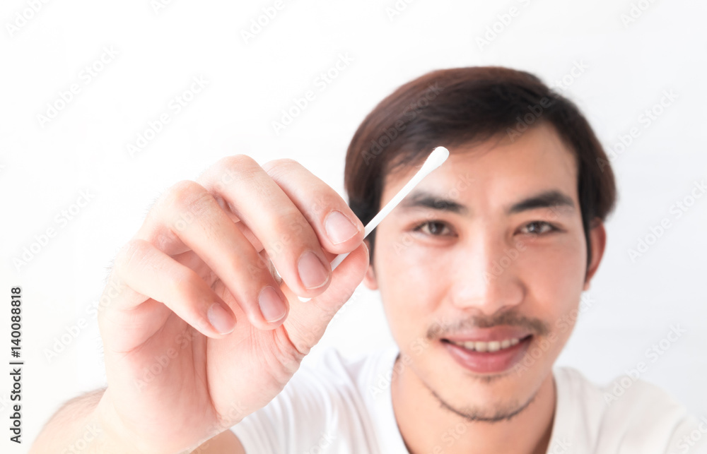 Closeup man hand holding cotton bud for cleaning ear , health care concept Closeup man hand holding cotton bud for cleaning ear , health care concept