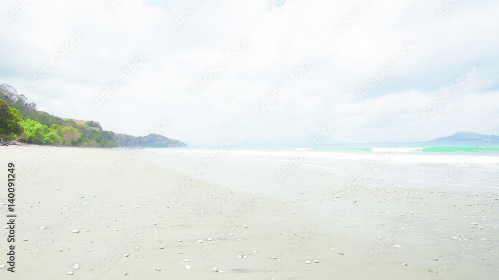 Empty white sand beach and clear blue ocean waves at Bajawa Ruting Flores in the morning.