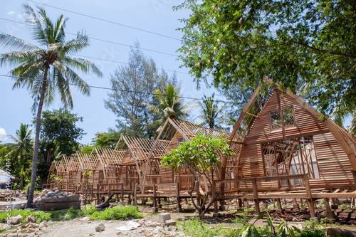 The construction of the guest houses is made from natural resources on the beach with palm trees.