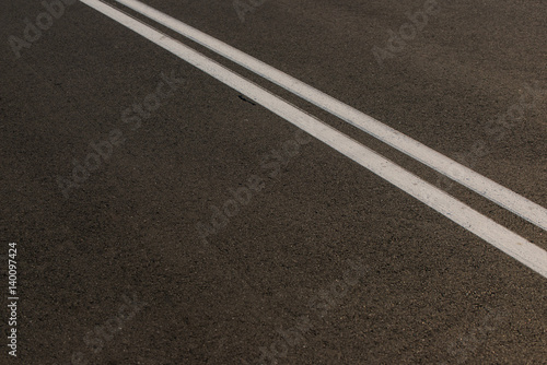Białe linie namalowane na drodze jako oznakowanie poziome