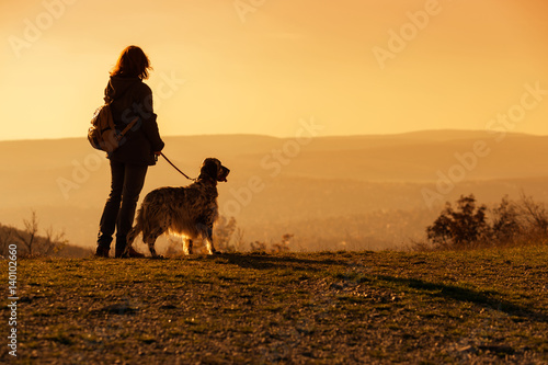 Konstfotografi Woman with her english setter dog on a mountain looking at the autumn landscape