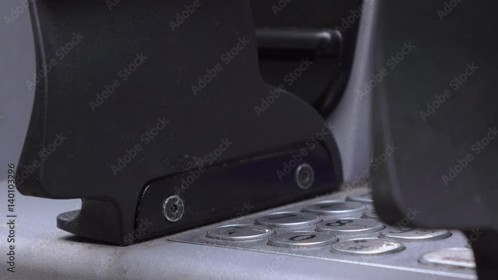 Person entering PIN code at ATM with shields blocking the view of others.
Person entering PIN code at ATM with shields blocking the view of others.