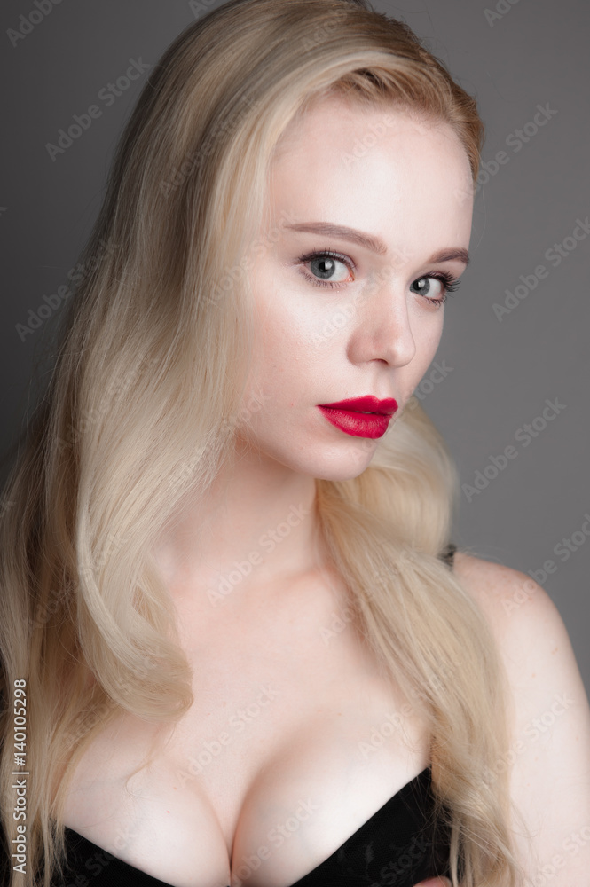 Beauty model girl with perfect make-up red lips and blue eyes looking at camera, wearing magenta bra. Portrait of attractive sexy young woman with blond hair. Beauty model girl with perfect make-up red lips and blue eyes looking at camera, wearing magenta bra. Portrait of attractive sexy young woman with blond hair.