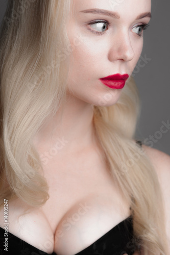 Beauty model girl with perfect make-up red lips and blue eyes looking at camera, wearing blue bra. Portrait of attractive sexy young woman with blond hair. 