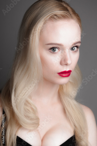 Beauty model girl with perfect make-up red lips and blue eyes looking at camera  wearing magenta bra. Portrait of attractive sexy young woman with blond hair. 