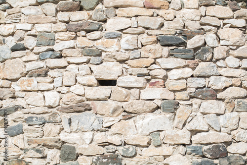 Ancient antique stone wall of medieval monastery or fortress. vintage background texture of masonry stone cement with cracks. Building facade.