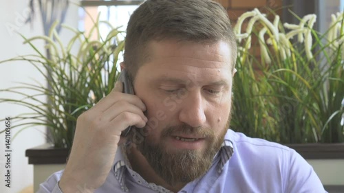 Businessman talking by smartphone, look at camera, portrait very close steadicam