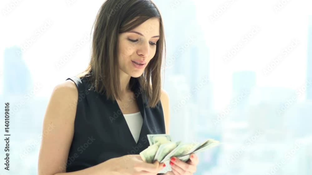 Happy, rich woman counting money standing by window at home, super slow motion 120fps
Happy, rich woman counting money standing by window at home, super slow motion 120fps