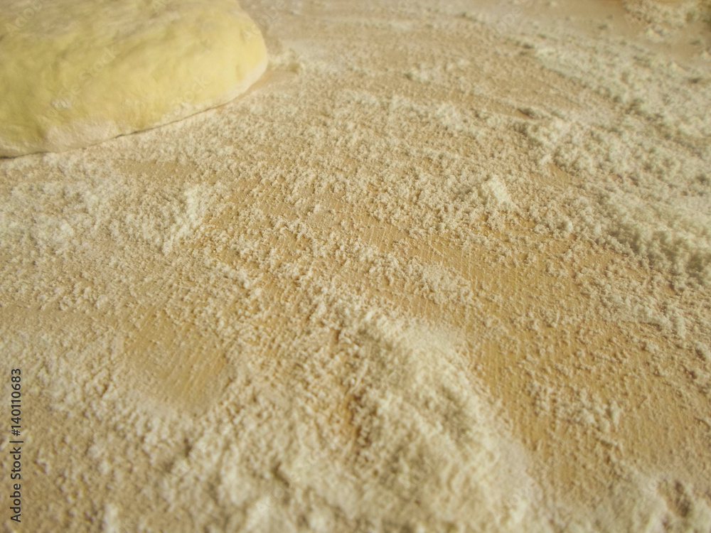 the dough and flour on a wooden board the dough and flour on a wooden board
