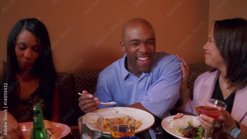 Right pan over couples at two booths in a restaurant Right pan over couples at two booths in a restaurant